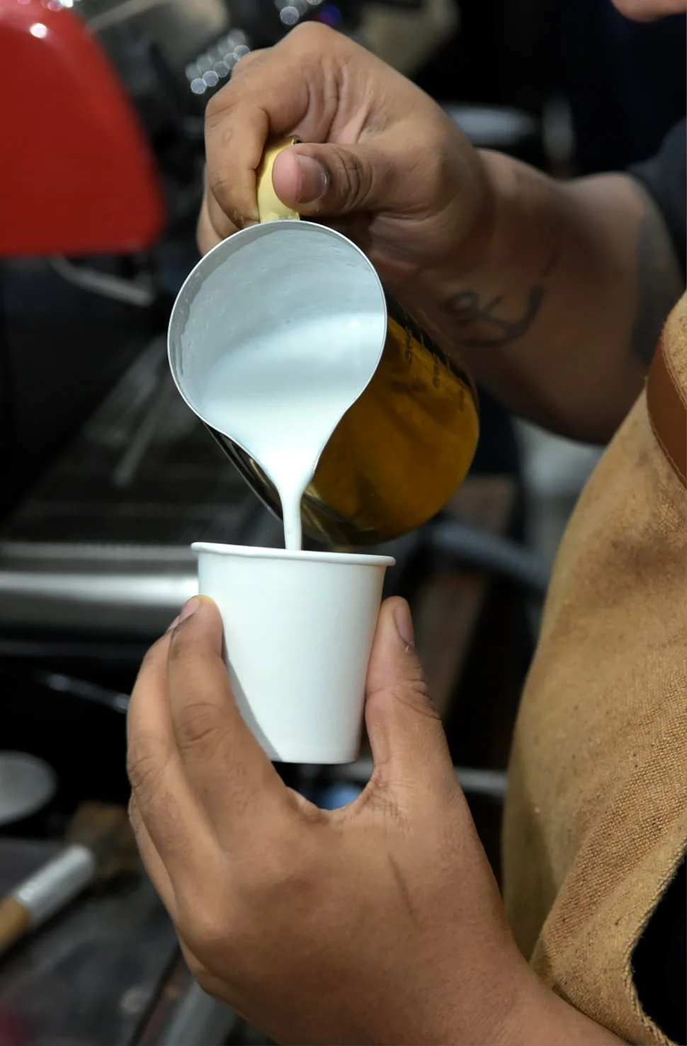 Barista preparando café com leite vaporizado ao vivo