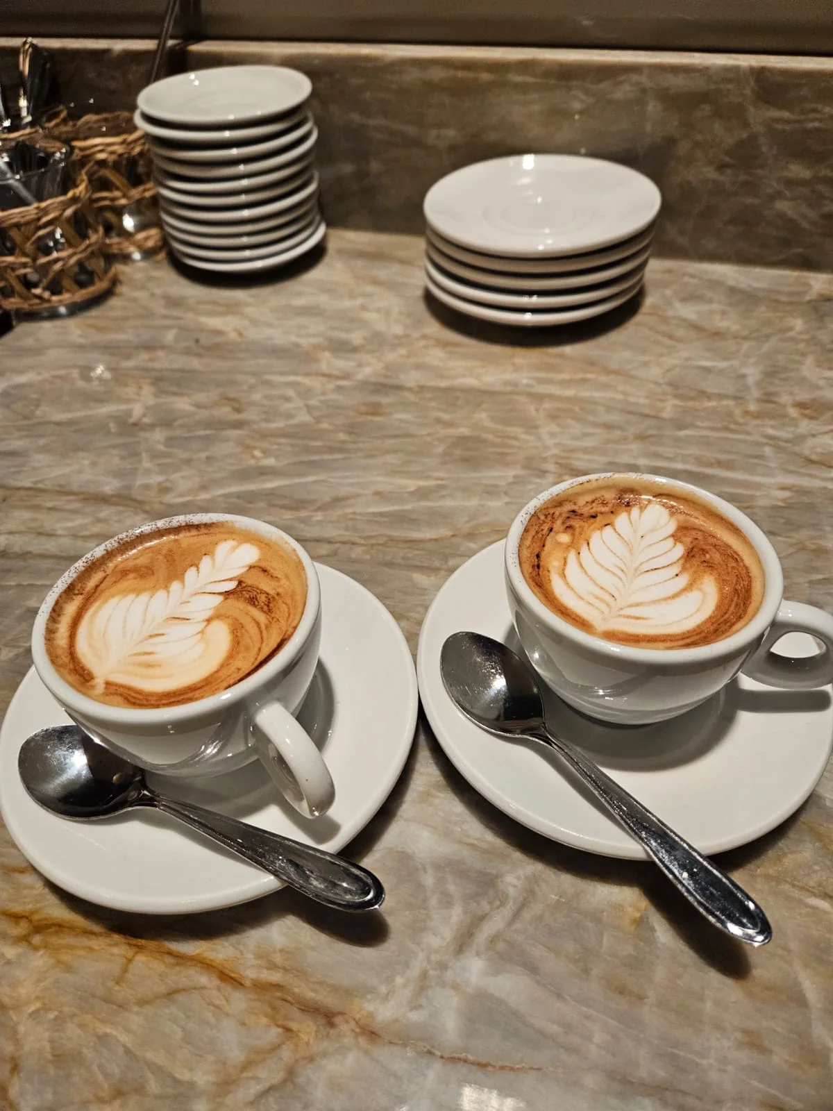 Dois cafés com latte art em xícaras de porcelana
